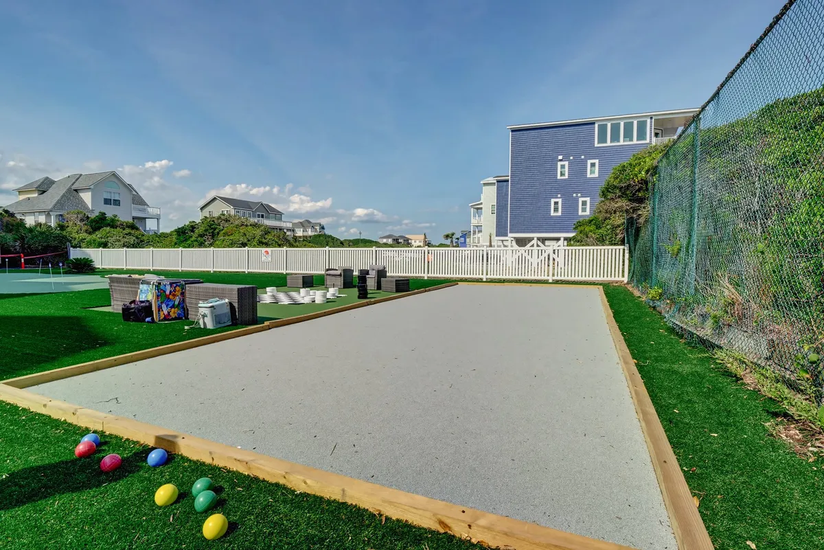 A playful bocce ball court with colorful bocce balls in the foreground, surrounded by houses, creating a lively and social atmosphere that's perfect for friendly outdoor competition and group fun.