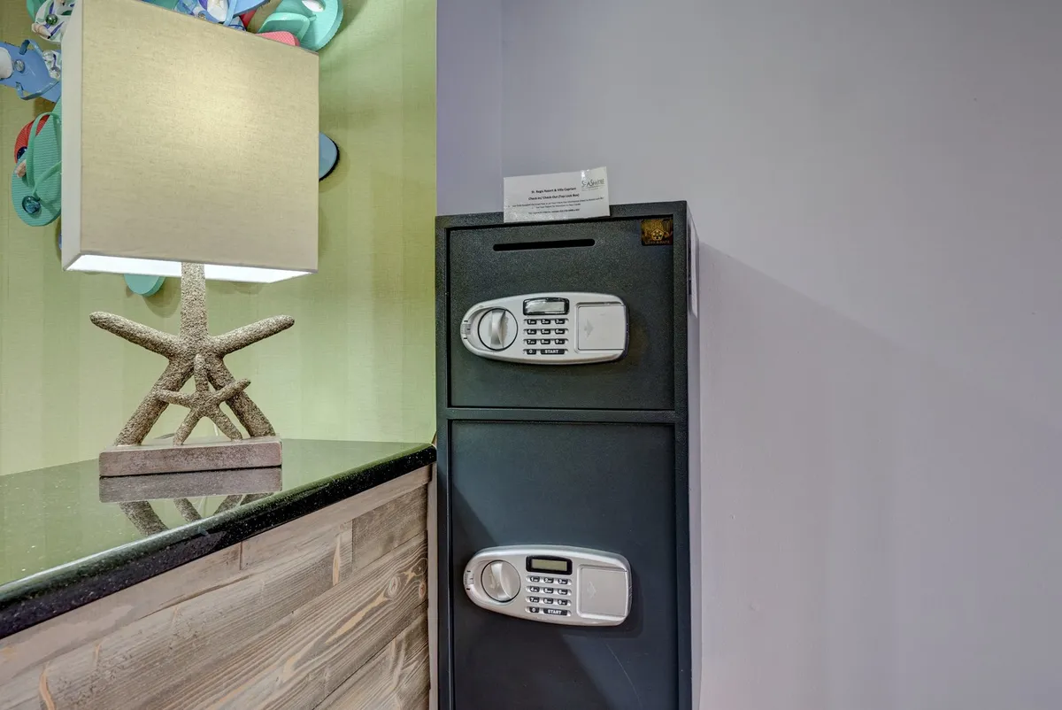 An inviting interior space with a lamp, safety deposit box, and wooden counter. The area exudes a sense of security and comfort, ideal for arrivals or daily routines.